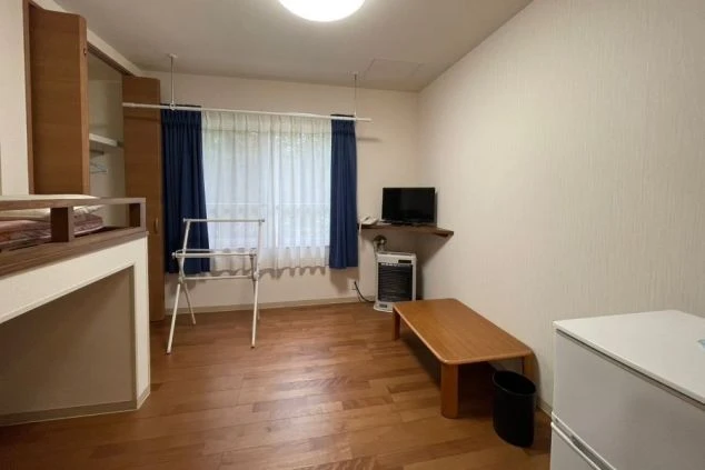 ワクトリの社員が出張で撮影した、リゾートバイトの寮の部屋の画像。ロフトベッドと下段にも寝具が置かれた二層式の空間で、クローゼットや物干しスタンドも見える。