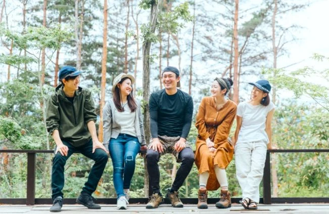 森のテラスで談笑するリゾートバイトの仲間たち。