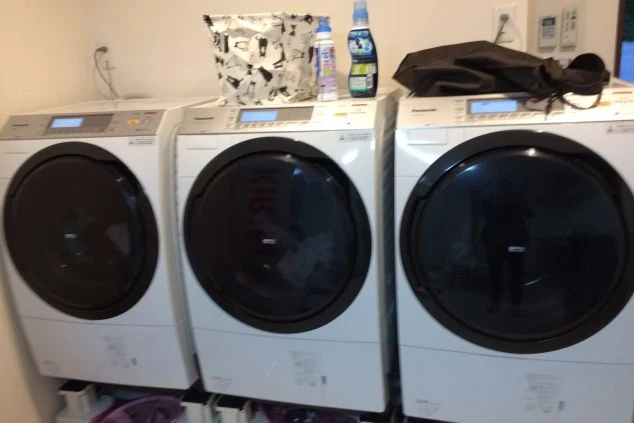 コインランドリーに設置された複数の洗濯機と乾燥機。寮内で洗濯ができるため、長期滞在でも便利に利用できる。