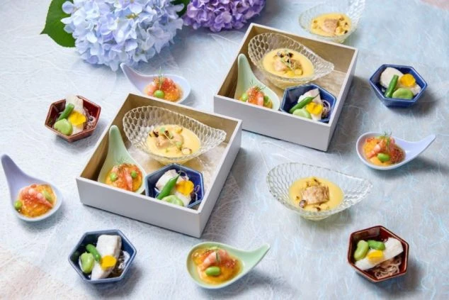 リゾートホテルの和食レストランで提供される、あじさいの花を添えた季節感あふれる創作和食の会席料理の画像。ウニや海老、いくらなど新鮮な海鮮を贅沢に使用し、繊細な器に盛り付けられた目にも鮮やかな料理。