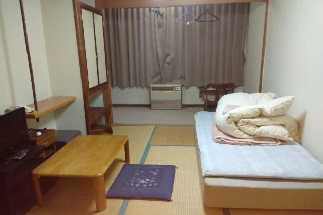 リゾートバイトの和室個室寮。寝具や家具が完備された、落ち着いた雰囲気の生活空間。