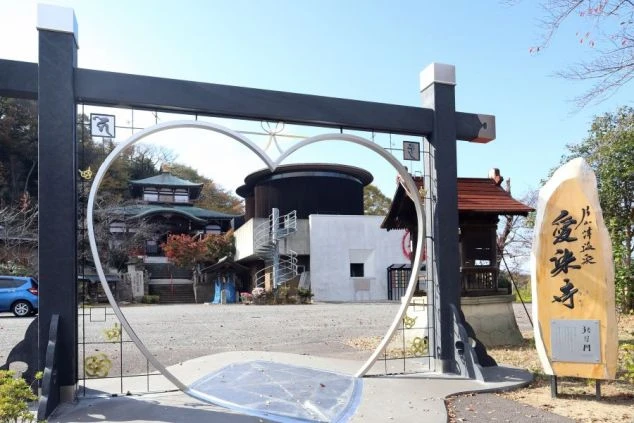 石川県加賀市の片山津温泉にある「愛染寺（あいぜんじ）」の猪目門（ハート型の門）と、その先に広がる情緒ある寺院の風景の画像。縁結びのパワースポットとしても人気の観光地。