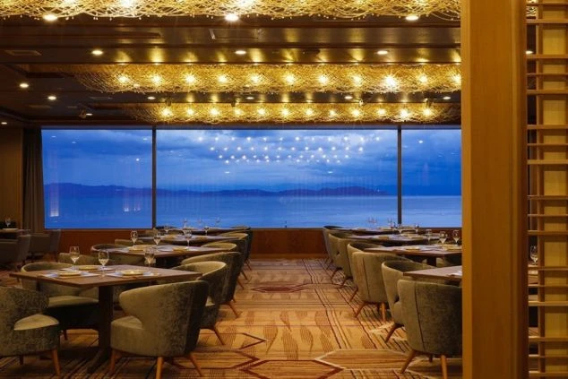 オーシャンビューが一望できるホテルの高級ダイニングレストラン。温かみのある照明とモダンなインテリアが並ぶ、落ち着いた接客業務の舞台。