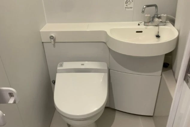 寮内のトイレ。温水洗浄便座付きの洋式トイレと、一体型のコンパクトな洗面台が設置されています。