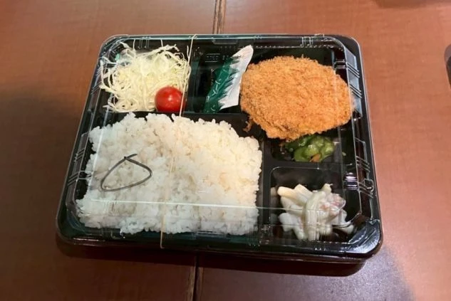 まかないを表現するイメージ画像。ご飯とコロッケ、サラダなどが数種類入ったお弁当。