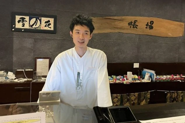 箱根のリゾートバイトでフロントに立つスタッフの写真。ワクトリオリジナル。