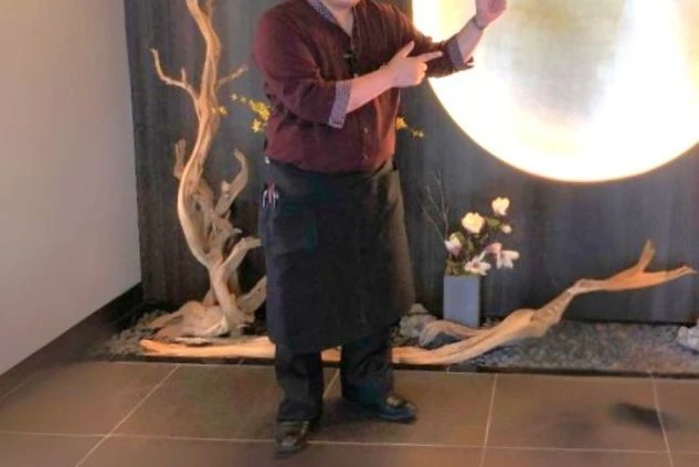 濃い赤いシャツに黒いズボンをあわせたレストランホールスタッフ用の制服