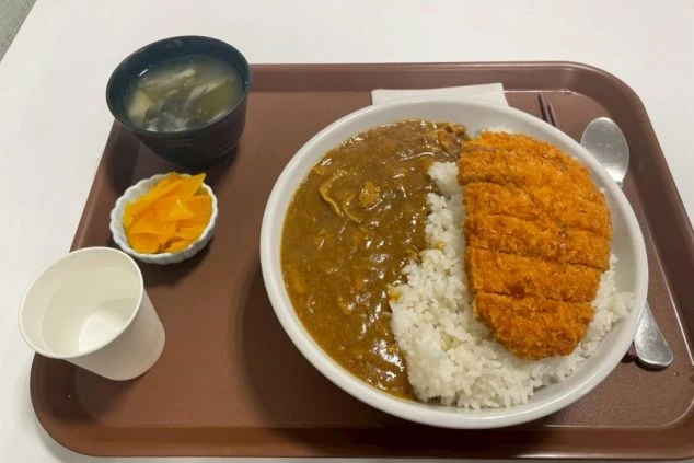 カツカレー、味噌汁、漬物が並んだボリュームのある食事メニュー