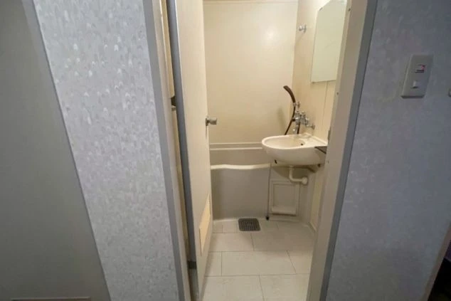 洗面台とバスタブが設置された、シンプルなバスルーム