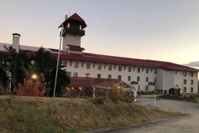 夕暮れ時にライトアップされたリゾートホテルの外観。寮完備の職場で充実した住み込み生活。