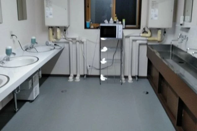 リゾートバイトの個室寮（相部屋寮）の共用洗面所の画像。奥には電子レンジが見える。
