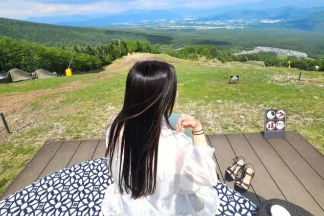 霧がかった広大な草原に立つ女性とリゾートバイトの非日常な景色