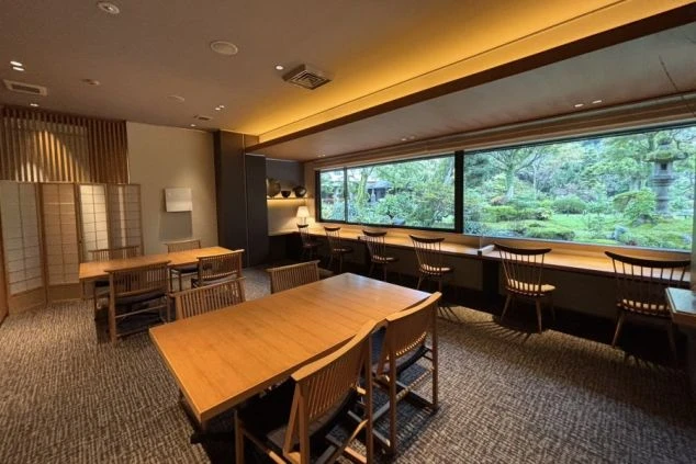 大きな窓から見事な日本庭園を一望できる旅館のレストラン。落ち着いた和モダンな空間で、リゾートバイト中の接客業務の舞台となります