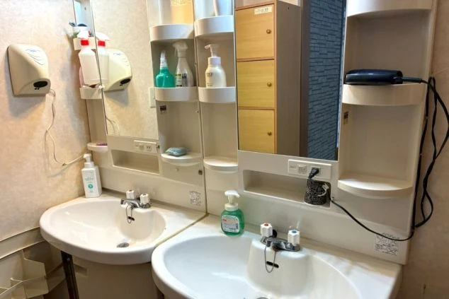 リゾートバイト寮の独立洗面台。鏡と収納棚が備わった清潔な洗面スペースで、朝の身支度もスムーズ。