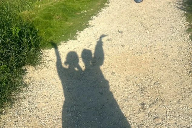 仲良く手を振るポーズで映るリゾートバイトスタッフ2人のシルエット画像。楽しげな休日の散策風景。