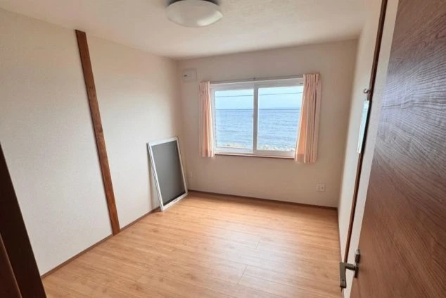 窓から景色が見える相部屋寮の部屋内の写真。新しくて綺麗な環境。