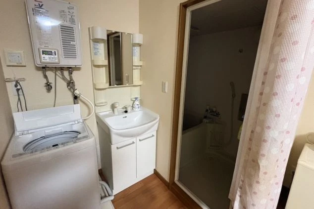 寮の室内に設置された専用の洗濯機とバスルーム。