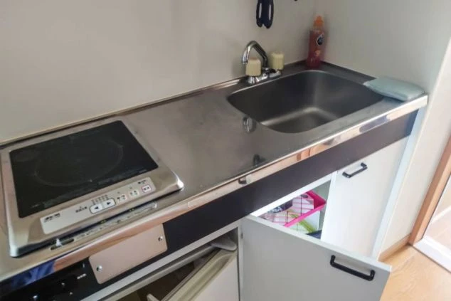 IHコンロとシンクが備え付けられた寮のキッチン。リゾートバイト中の自炊も可能な設備