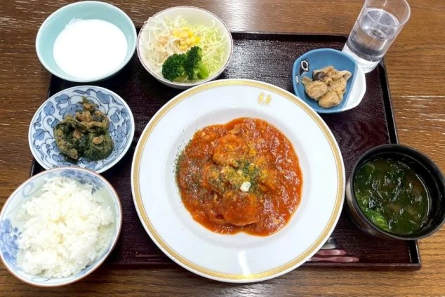 メインの煮込み料理、ご飯、味噌汁、サラダなどが並ぶ定食