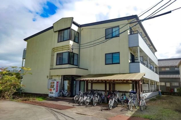 駐輪場や自販機が設置されたリゾートバイトの寮外観。周辺環境も落ち着いた住みやすい建物