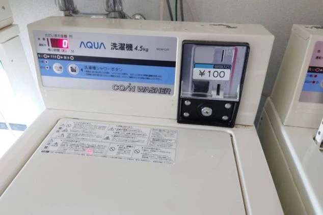 リゾートバイト寮に完備されたコインランドリー。100円で利用可能な清潔感のある洗濯機