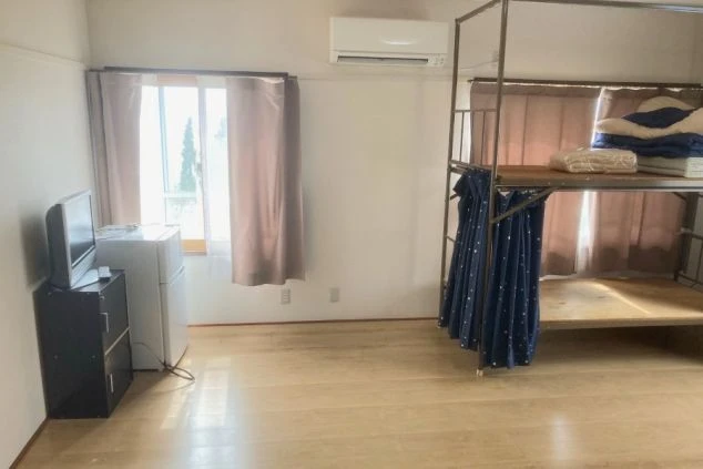 リゾートバイトの個室寮。テレビ、冷蔵庫、エアコン、収納棚が完備された、すぐに生活を始められる室内。