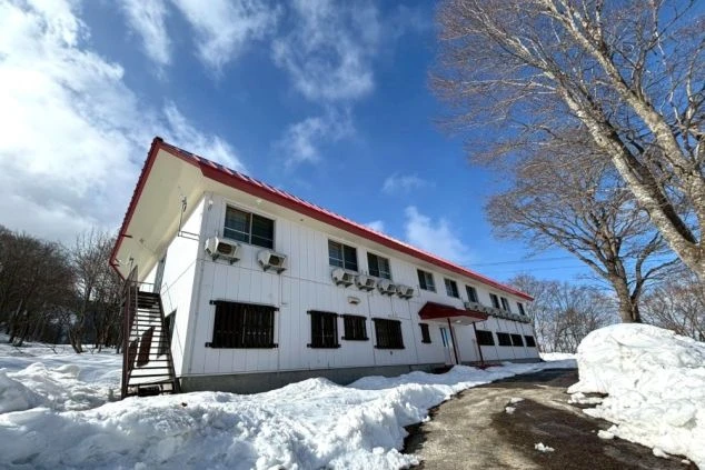 新潟・妙高エリアのリゾートバイト寮外観。雪景色に囲まれた、冬の住み込みに最適な2階建てスタッフ寮。