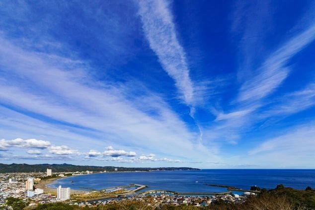 青空と広大な海が広がる千葉県鴨川市の海岸線。リゾートホテルや街並みが一望できる開放的な風景。
