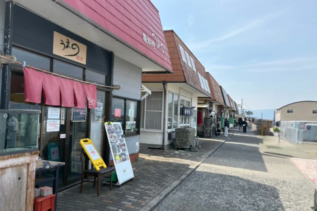 赤い屋根と暖簾が特徴的な、海沿いに並ぶレトロな飲食店街。観光地のリゾートバイトはワクトリ。