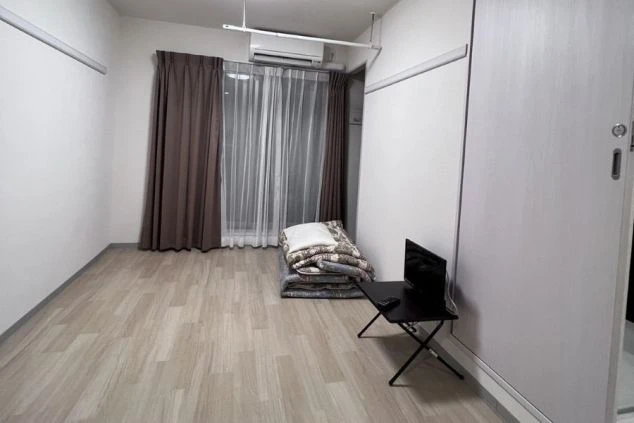 エアコン付きの清潔感のあるリゾートバイト寮の個室の画像。フローリングと収納、布団が用意されており、快適な完全個室寮であることをアピール。